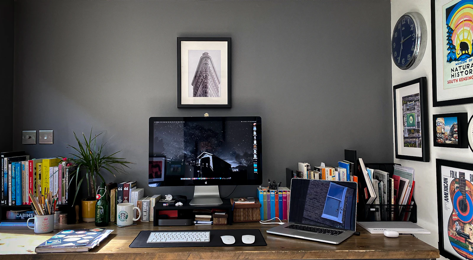 Creative home office and digital workspace Home office desk with a desktop monitor, laptop, books and framed artwork