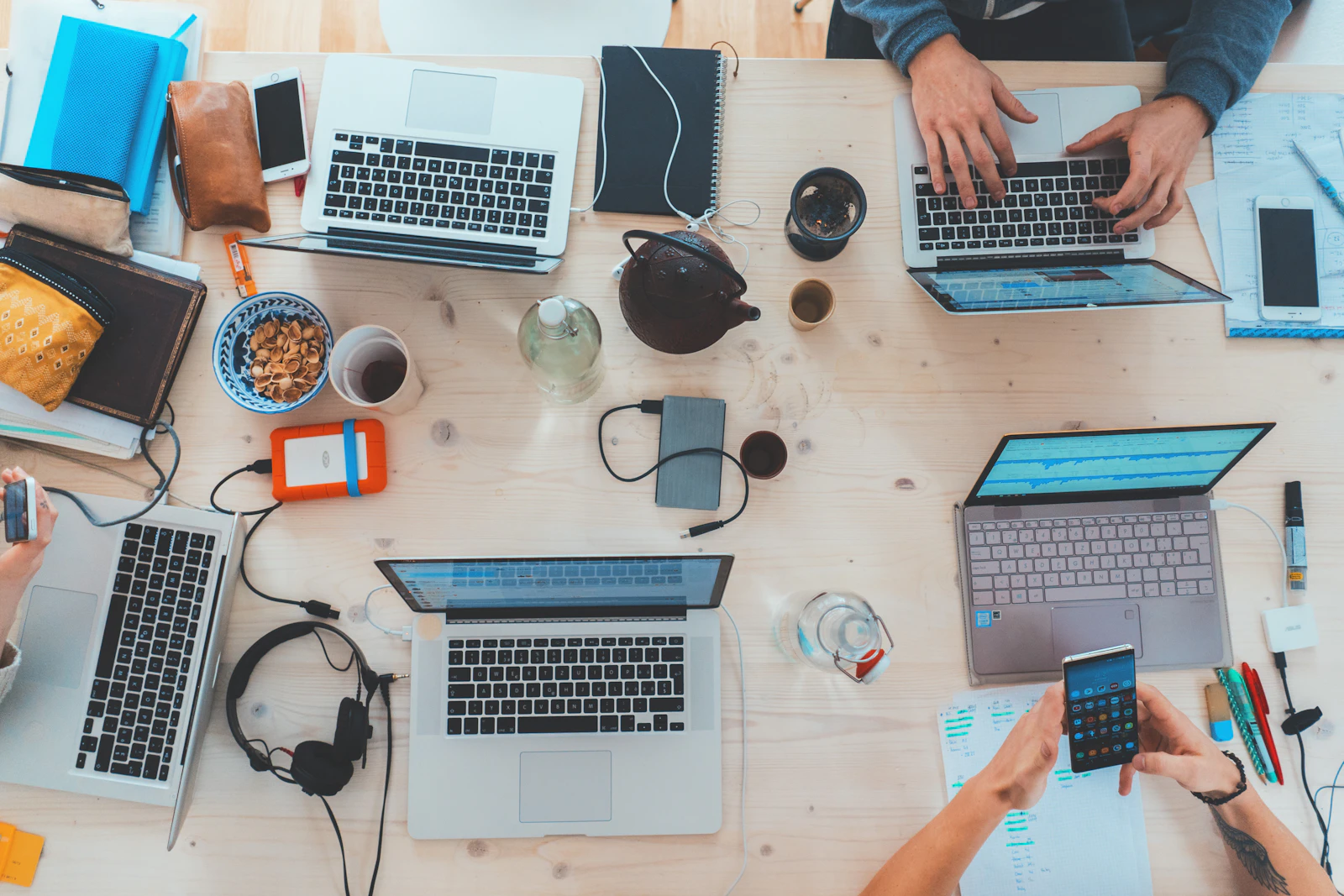 People collaborating around a table with laptops